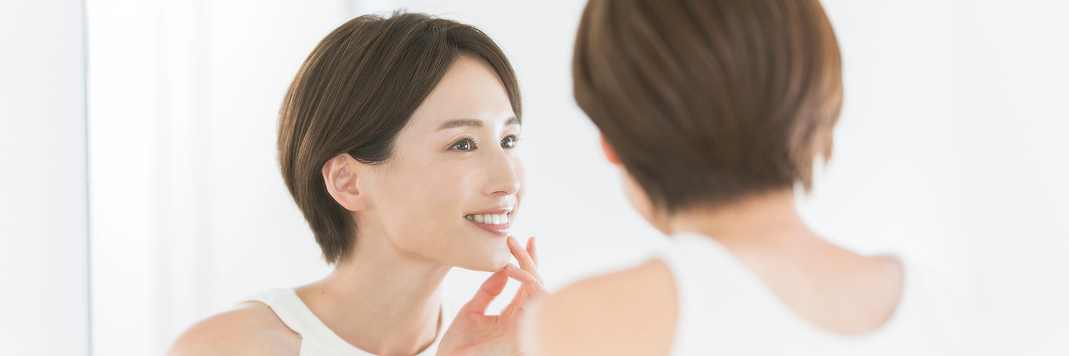 鏡で自分の歯を見る女性